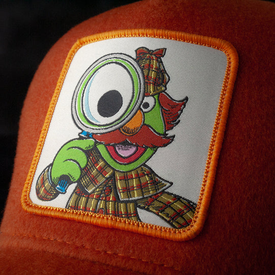 Close-up of Sherlock Hemlock from Sesame Street on woven patch attached to trucker cap crown