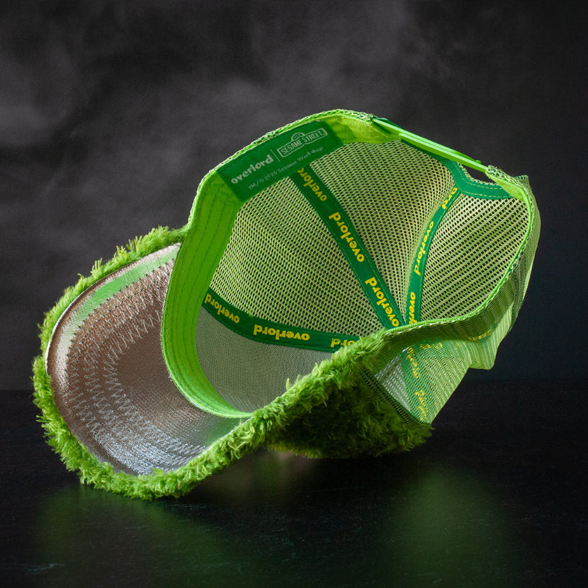 Inside view of green faux fur trucker cap hat with metallic silver underbrim