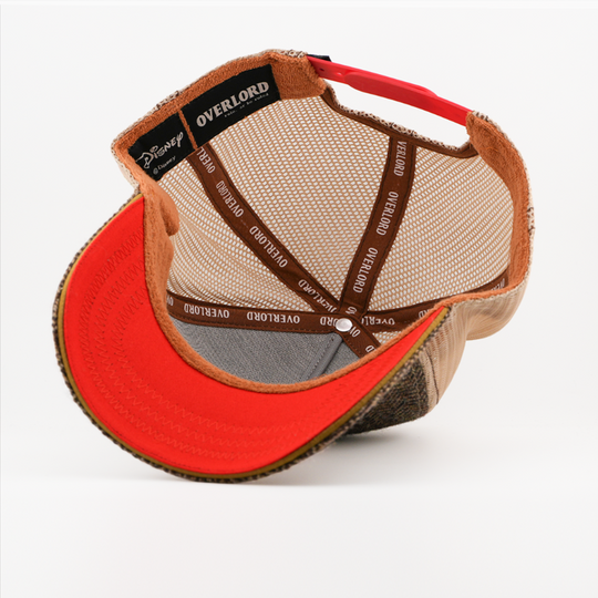 Underside of the Statler retro trucker cap, showing a solid orange brim, a Disney tag, tan mesh crown, and brown Overlord branded taping with white text.
