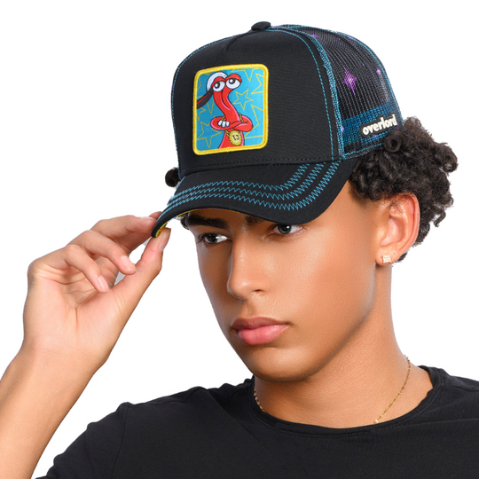 Man wearing black trucker cap hat with black starry mesh featuring Toejam from Toejam and Earl on woven patch attached to crown