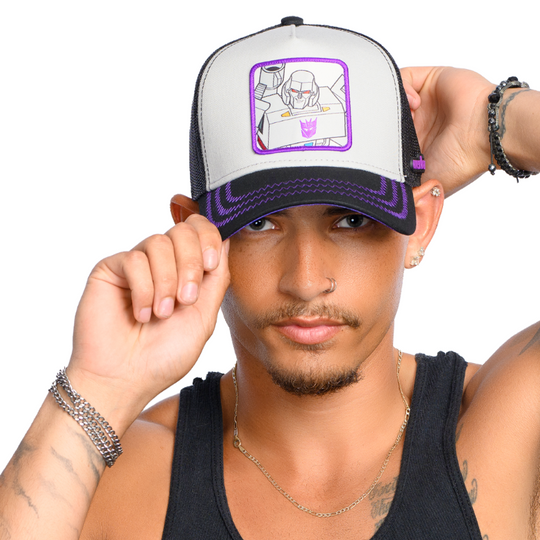 Man wearing gray and black trucker cap hat featuring Megatron from Transformers on woven patch attached to crown