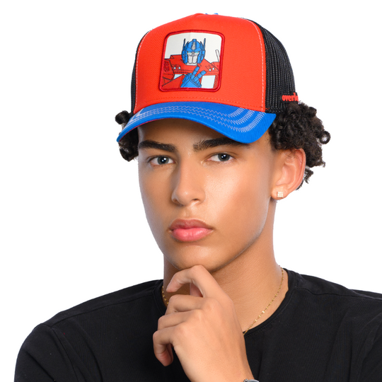 Man wearing red and blue trucker cap hat featuring Optimus Prime from Transformers on woven patch attached to crown