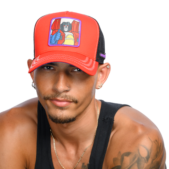 Man wearing red trucker cap hat featuring Starscream from Transformers on woven patch attached to crown