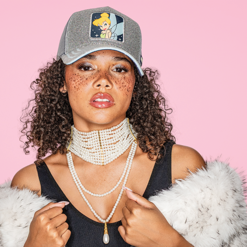 Model wearing the silver glitter-textured Tinker Bell from Disney's Peter Pan retro trucker cap with a matching brim.