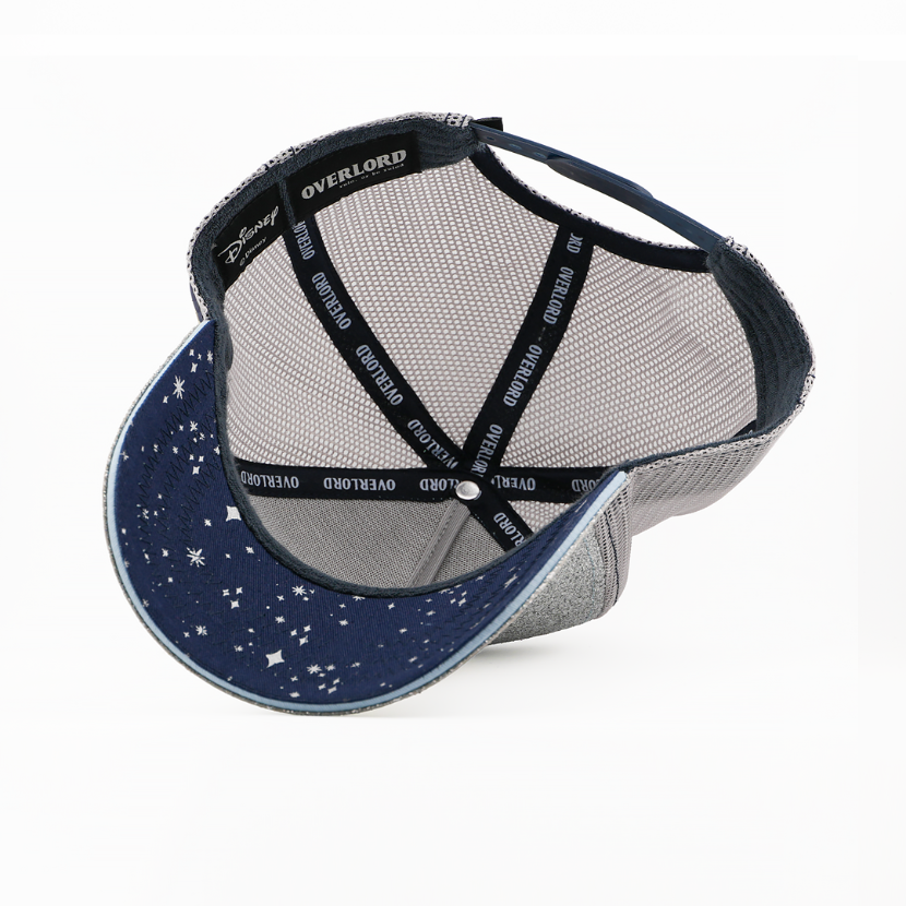 Underside of the Tinker Bell from Disney's Peter Pan retro trucker cap showing a navy starry-print brim, a Disney tag, gray mesh crown, and black Overlord branded taping.