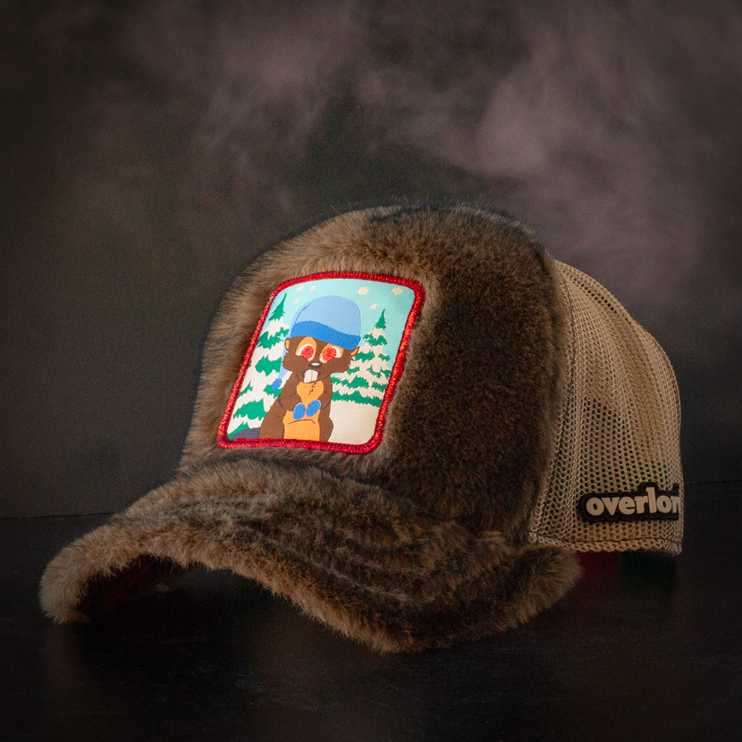 Faux beaver fur trucker cap with khaki mesh featuring a woven patch of Woodland Critter Beaver from South Park attached to the crown.