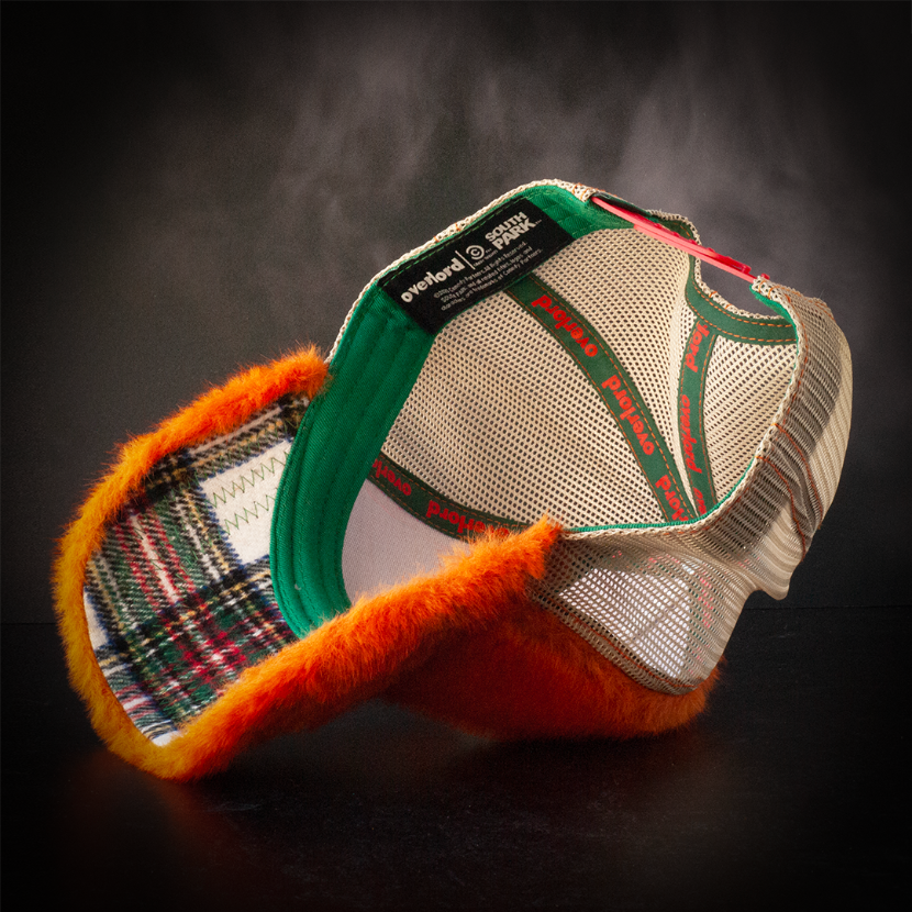 Inside view of faux fox fur trucker cap with white, green, red, and yellow soft flannel underbrim.