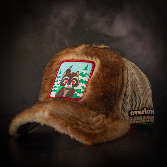 Faux raccoon fur trucker cap with khaki mesh featuring a woven patch of Woodland Raccoon from South Park attached to the crown.