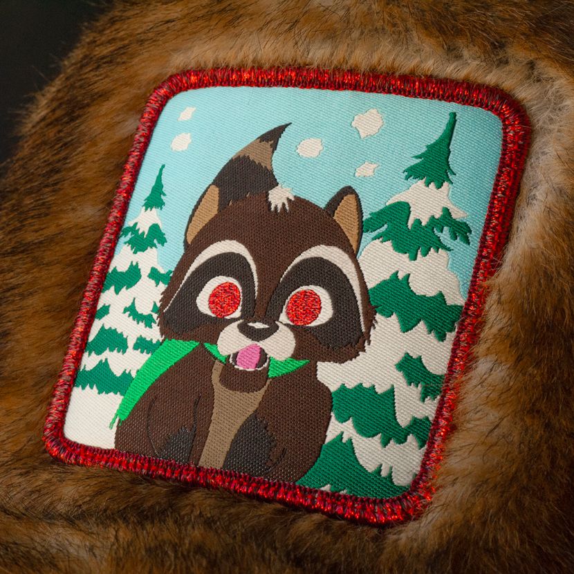 Close up of a woven patch of Woodland Raccoon from South Park attached to the crown.