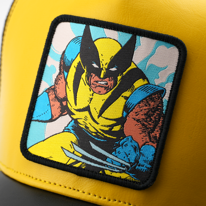 Close-up of a woven Marvel's Wolverine patch with claws bared, stitched onto glossy yellow cap fabric.