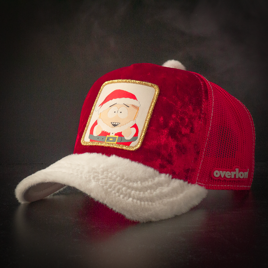 Red crushed velvet trucker cap with white faux fur brim and red mesh featuring a woven patch of Cartman from South Park wearing a Santa suit attached to the crown.