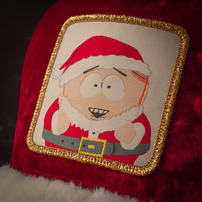 Close up of a woven patch of Cartman from South Park wearing a Santa suit attached to the crown.