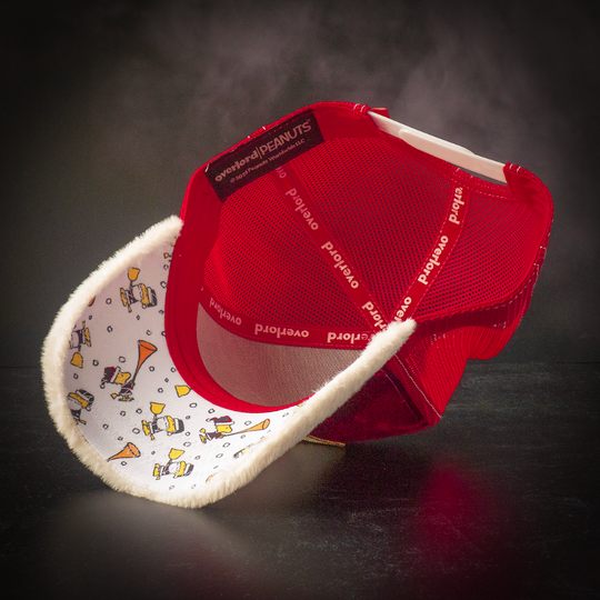 Inside view of a red crushed velvet trucker cap with little Woodstock in a Santa suit scattered on the white underbrim.