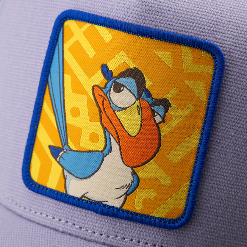 Close-up woven patch of Zazu from Disney's The Lion King with a skeptical expression, on a yellow patterned background with a blue border, stitched onto a purple corduroy-textured retro trucker cap.